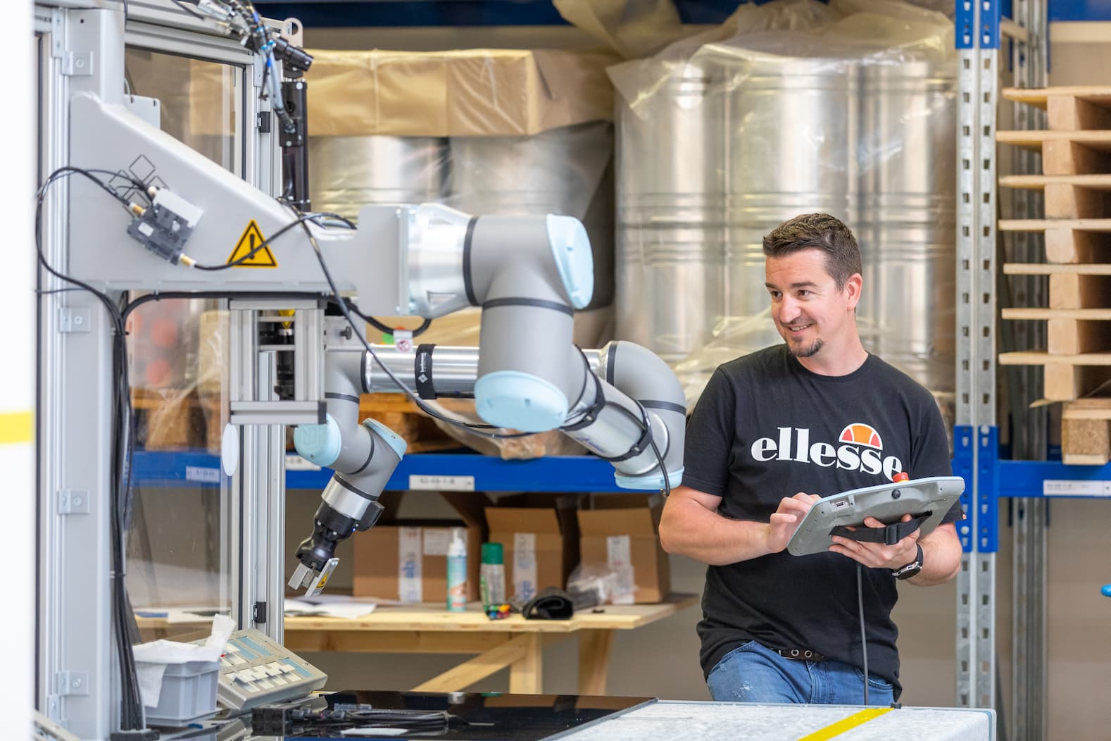 Roboter Arm 2 Ein Mann bedient einen Roboter Arm per Fernbedienung