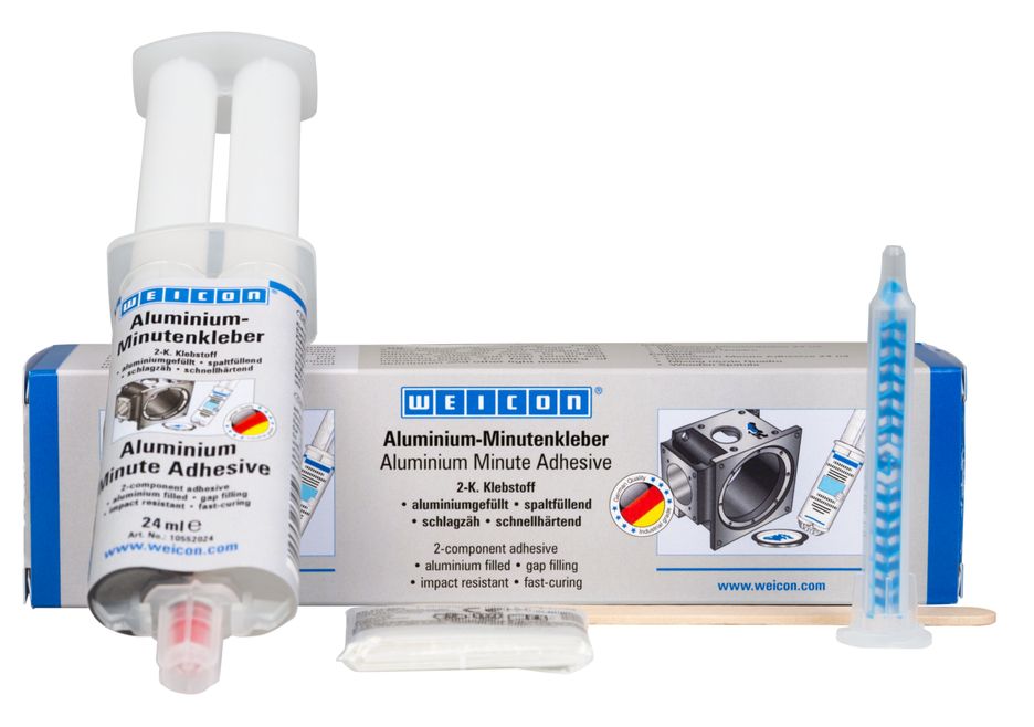 WEICON Aluminium-Minutenkleber Reparaturset: aufrechter 24ml Tuben-Spender mit Aufschrift, flache graue Verpackung mit Produktinfos, blaue Mischdüse, kleines Päckchen und Holzspatel vor weißem Hintergrund. Aluminiumgefüllt, schnellhärtend.